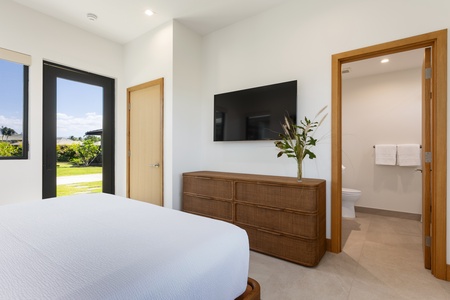 (Bedroom 4) Your serene bedroom features crisp white linens, a wall-mounted TV for relaxation, and garden views through large windows.