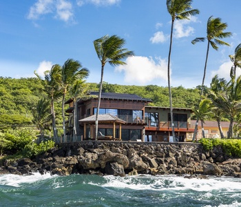 Secluded coastal villa nestled in greenery with panoramic oceanfront access.