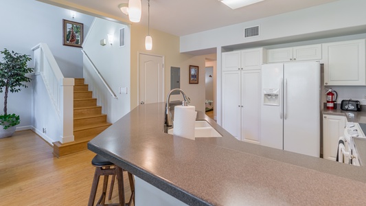 The stairs are located near the kitchen.