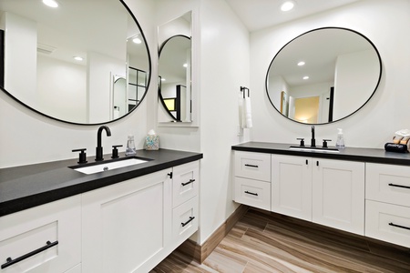Kapalua Ridge 1421’s modern bathroom features dual vanities, sleek countertops, and stylish round mirrors.