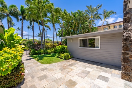 A tropical paradise awaits with lush palms framing manicured lawns and a private patio, perfect for morning coffee or evening relaxation under swaying fronds.