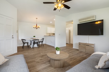 Relax in your bright, modern living space with a comfy sofa, dining table, and large TV for your entertainment.