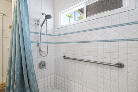 Accessible walk-in shower with grab bar for added safety and mobility.