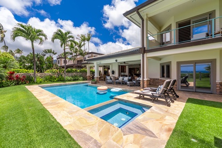 The pool, spa, and lush lawn blend seamlessly into a stunning oceanfront setting.
