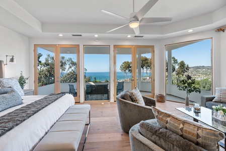 Primary bedroom with spacious seating area and private balcony with full ocean view.