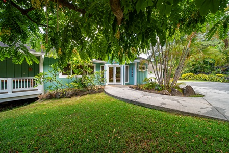 Front garden entry shaded by mature trees, leading to double doors that open into a tranquil island retreat.