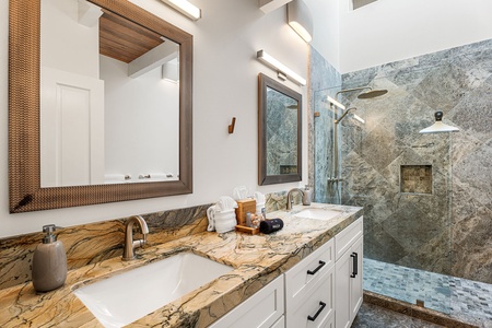 Refresh in a private bath with dual vanities and a spacious walk-in shower.