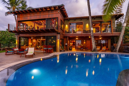 Salt water infinity pool surrounded by tropical palm trees and loungers.