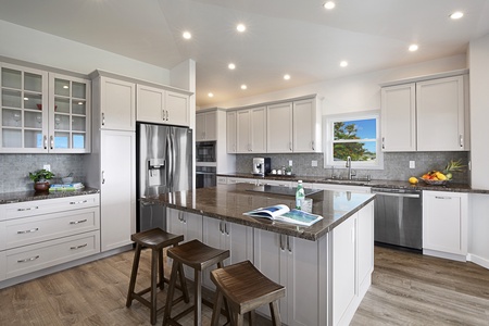 Bright, well-appointed kitchen with stainless steel appliances, a spacious island, and ample counter space for meal preparation.