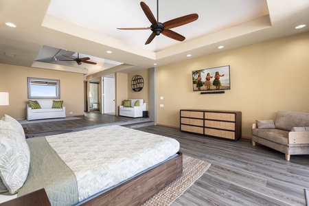 Unwind in this spacious primary bedroom where tropical breezes from ceiling fans complement the ocean-inspired decor and plush seating nook.