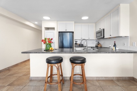 Updated kitchen bar area with high-top seating—perfect for sharing meals or planning your Kona adventures.
