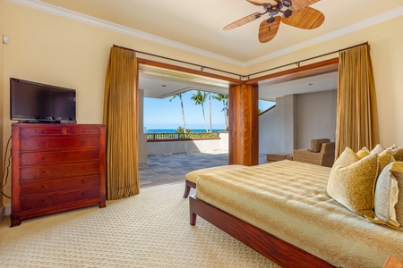 Wake to stunning ocean and sunset views from this luxurious upstairs primary bedroom.