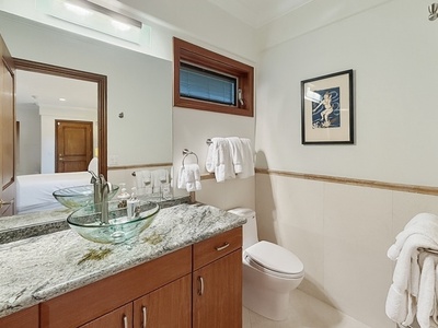 Your elegant bathroom features granite counters, glass vessel sinks, and plush white towels—a perfect retreat for your daily refresh.