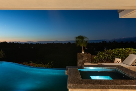 Outdoor dining area with comfortable seating and lounge chairs, surrounded by tropical landscaping