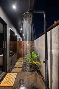 Indulge in an invigorating rinse under the private outdoor rainfall shower surrounded by tropical blooms.
