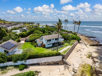 Stunning oceanfront property surrounded by lush tropical gardens and swaying palm trees, offering direct access to pristine sandy shores and crystal-clear ocean waters.