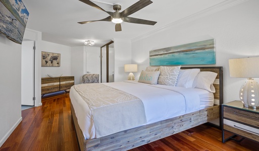 The spacious bedroom features a comfortable king-sized bed and a calming, beach-inspired decor.