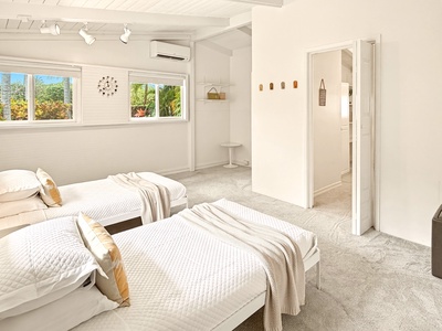 Wake up in your serene twin bedroom with tropical garden views, crisp white linens, and modern comfort.