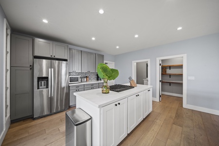 Custom cabinetry, stainless steel appliances, and a gas range anchor this chef-ready kitchen in functionality and style.