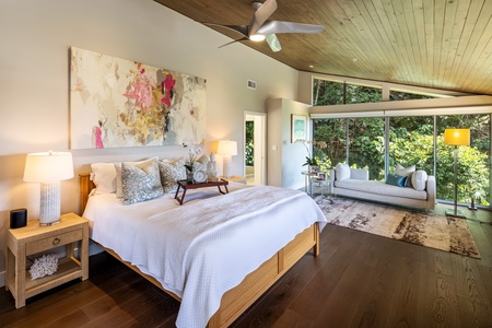 Primary suite with king bed, vaulted ceiling, and lush garden views—your private mountain escape.