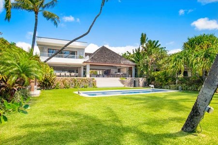 Expansive backyard with heated pool and swaying palms—just steps to the shoreline.