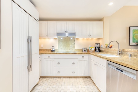 Stylish and functional kitchen with white cabinetry and warm lighting.