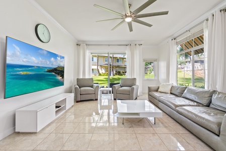 Spacious and bright living room with plush seating and a view of lush greenery—perfect for relaxing after a day at the beach.