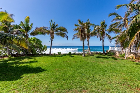 Expansive grassy lawn leading directly to the shoreline—pure island bliss.