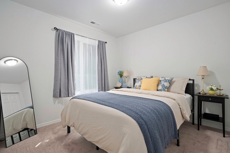 Unwind in the cheerful guest room with a cozy queen bed, perfect for a restful night after a day on the lake.