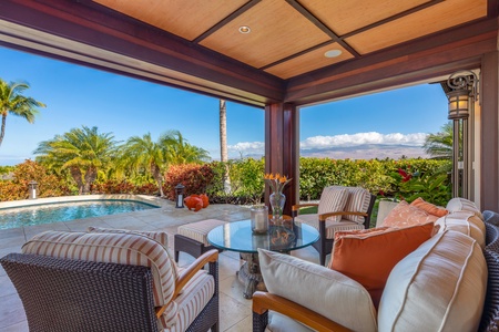 View of the home from the pool framed by palms and twilight skies.