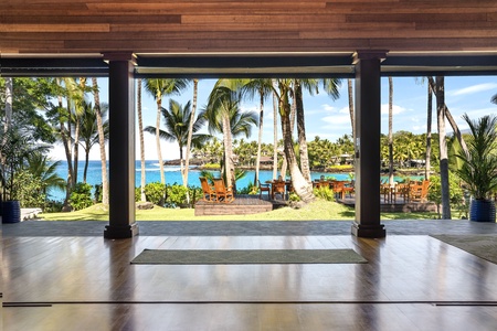 Step into your tropical paradise where polished floors meet breathtaking ocean views through floor-to-ceiling windows.