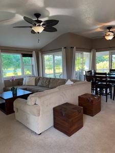 Comfortable living room with ample seating and ceiling fan.