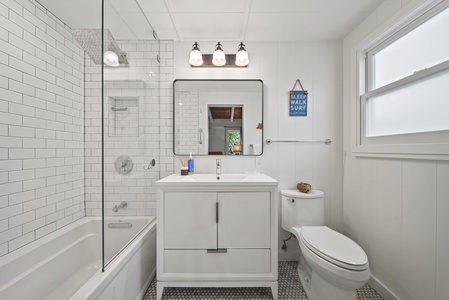 Ensuite bathroom featuring a modern vanity and bright lighting—ideal for refreshing after beach days or surf sessions.