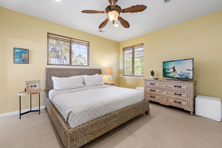 Bright bedroom featuring a king-sized bed, large windows, and a flat-screen TV for relaxation.