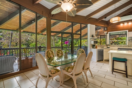 The main room opens to the greenery on nearly every side, beams overhead.