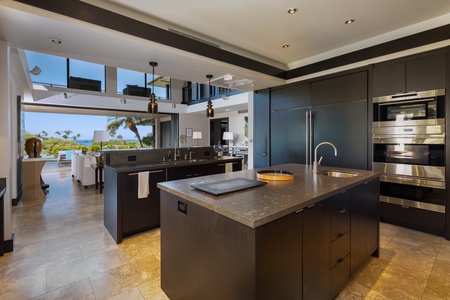 Cook and connect in the chef’s kitchen, where floor-to-ceiling windows frame lush tropical scenery.