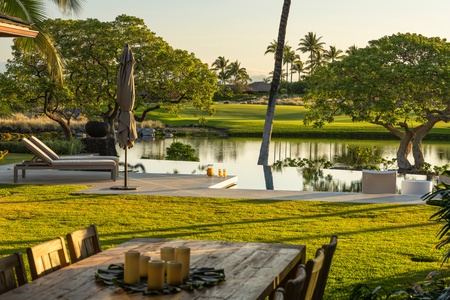 This infinity-edge view creates a stunning optical illusion, blending the tranquil pool with the golf course pond beyond for a seamless island escape.