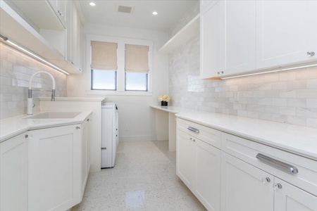 Bright utility space with ample counter area and integrated laundry facilities.