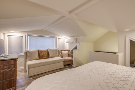 A beautifully designed guest bedroom with a cozy reading nook and serene ambiance.