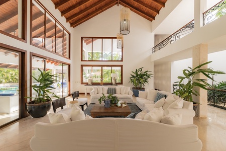 Spacious living area with high wooden ceilings and abundant natural light, perfect for relaxation and socializing.