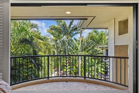 Serene balcony overlooking vibrant palm trees.