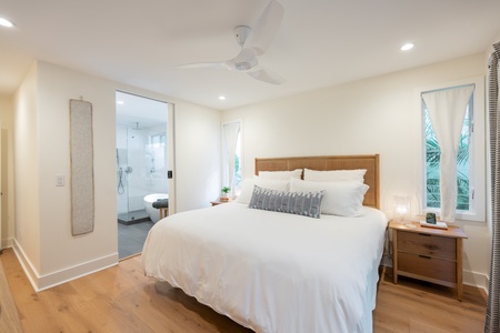 Experience luxury in our primary suite, complete with plush bedding, private lanai access, and calming coastal decor.