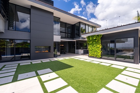 Contemporary villa centered around a landscaped courtyard and outdoor fireplace.