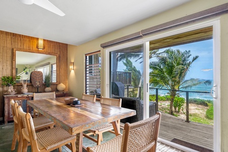 The tropical dining room frames stunning ocean views through floor-to-ceiling windows, where palm trees sway just beyond your private terrace.