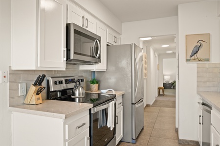 Cook with convenience in the modern kitchen, featuring stainless steel appliances and wide counter spaces, before heading out to explore sunny La Jolla.
