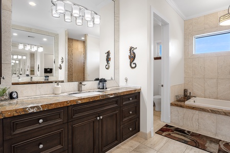 Stylish primary bathroom with dual vanities and luxury finishes.