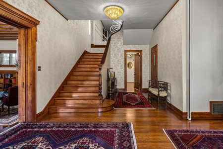 Grand staircase with original wood banister and chandelier.