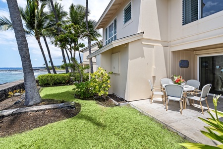 Ground-level lanai entrance with lush landscaping and quick lawn access to ocean views.