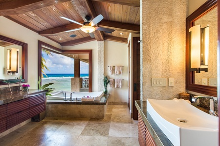 Spa-style primary bathroom with soaking tub and spectacular ocean views.
