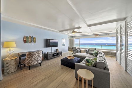 Relax in your bright, coastal-themed living room with stunning ocean views and cozy seating perfect for unwinding after beach adventures.